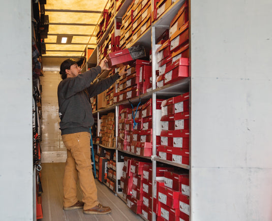 Shoeteria employee inside shoemobile grabbing a pair of shoes