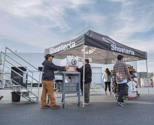 Shoeteria employee helping customer with purchase