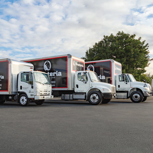 Three Shoeteria shoemobile trucks parked next to each other